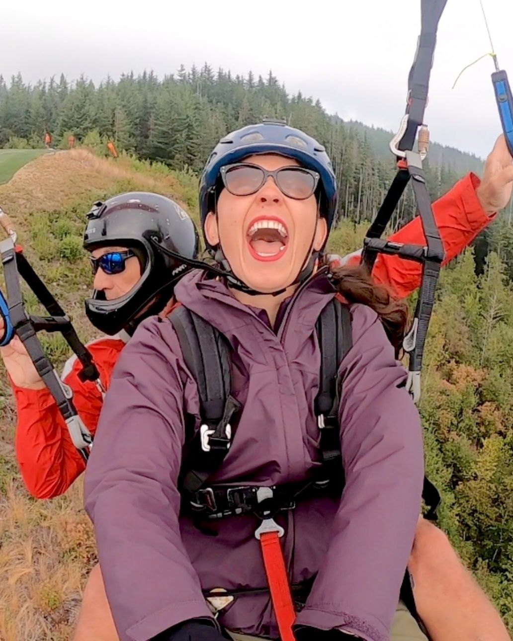 Foot-launch tandem flight with smiling passenger